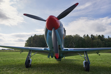 Ultralight replica of legendary soviet fighter plane Yakovlev Yak 3 in marking and camouflage of french Normandie-Niemen Fighter Regiment landed on grass airfield in Czech Republic in sunny summer day