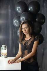 Pretty young brunette posing near a table.