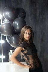 Alluring young brunette posing near a table.