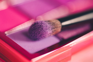 Purple eye shadow with brush closeup. Make up product. Selective focus.