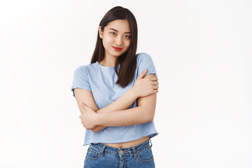 Obraz premium Tender feminine romantic silly asian girl dark short hairstyle touch own body hugging cross arms tenderness lovely pose smiling caring relaxed camera standing white background delighted