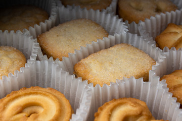Box of sugar cookies in paper baskets in the dark