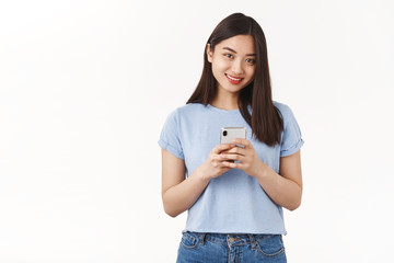 Cheerful tender feminine asian girl hold smartphone texting look camera delighted amused carefree positive smile toothy photographing friend during summer vacation happy pride