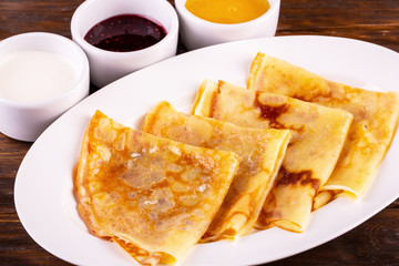Pancakes with sour cream, jam and honey