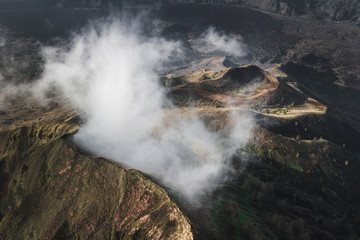 Aerial view of Batur volcano caldera in Bali. Volcanic black texture and crater rim, view from above, drone shot