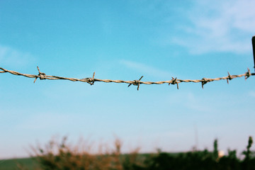 Barbed wire on background of blue sky