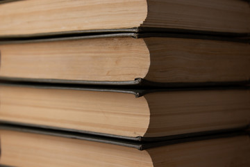 Several old books lie horizontally close-up.