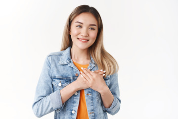 You in my heart. Tender caring cute asian young girl blond hairstyle hold hands chest pleased...