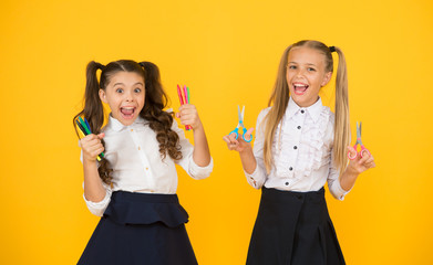 Pick the perfect colors for drawing. Happy small children holding drawing and cutting tools. Little girls using markers for drawing and scissors for cutting. Drawing lessons and crafts for kids