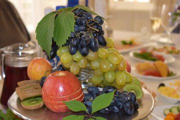 Fruit vase, grapes, Apple, kiwi decorated with grape leaves. 