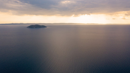 Aerial sunset view of amazing Neos Marmaras cityscape and distant turtle island in Greece.