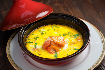 Fish soup in a pot with a red lid. catering menu