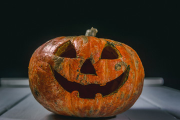 Halloween pumpkin on a wooden table on a background of white boards. Halloween background.