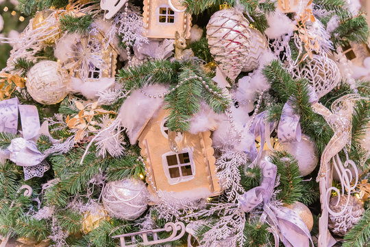 Christmas and New Year holidays background. Christmas tree decorated with white and gold balls, jinger houses, cones and ribbons. Celebration concept
