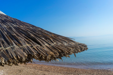 Mediterranean sea, beach vacation, close-up of reed umbrella