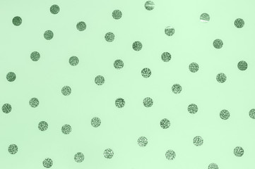 Festive holiday background. Photo of big confetti sparkles on mint backdrop. Celebration concept. Trandy color of 2020. Top view, flat lay