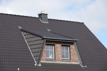 Haus mit Schornstein und Dachgaube mit Fenstern