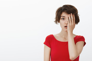 Shocked speechless impressed woman cover half face palm open mouth ambushed wondered gasping stare camera stunned impressed upset shook troublesome news standing white background