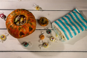 Halloween pumpkin and candies on a white table