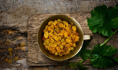 Raisins in a bowl on a wooden table