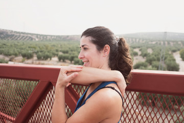 mid adult woman warming up on a bridge before and after run