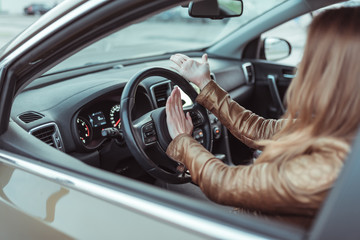 A woman driving car, clicks on a signal, swearing obscene ones to take curses, aggression, stress, traffic disturbance, road accident, emergency, hand gesture aggression discontent scream.