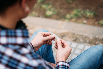 Close up of a man´s hands rolling a cigarrette up