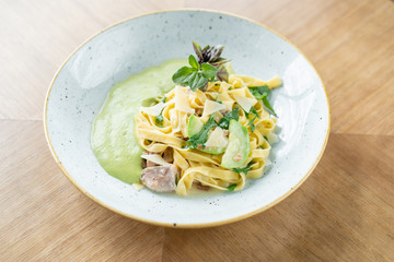 Italian pasta tagliatelle with zucchini, Turkey and green sauce. Parmesan cheese