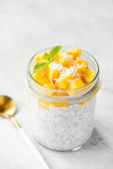 Chia seed pudding with mango and coconut milk in glass jar, isolated