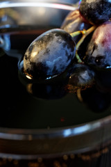 Black and red grapes in a glass with homemade wine, juice or alcohol. Farm harvest on the counter of the fair. Autumn still life.
