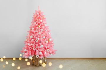 Pink christmas tree and christmas decorations white and gold color in white interior