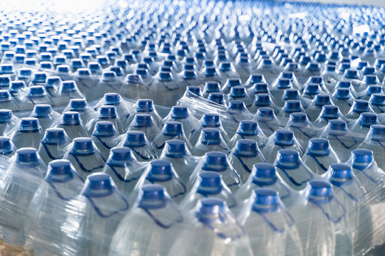 Many plastic bottles with drinking pure water and blue caps