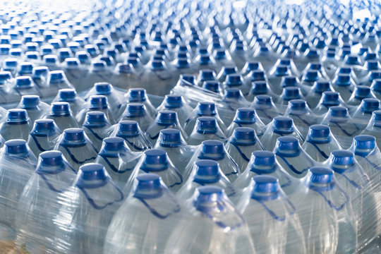 Many plastic bottles with drinking pure water and blue caps