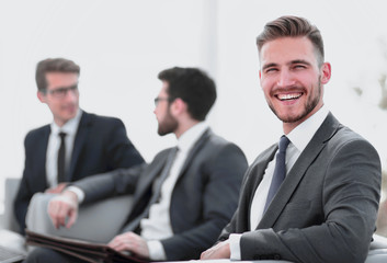 smiling businessman in the background of the office.