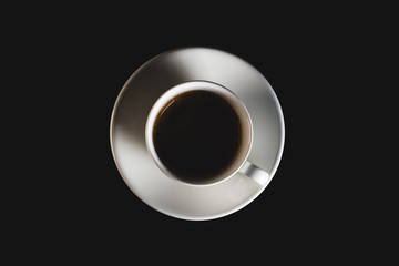 White espresso cup with black coffee on black background. Coffee cup top view