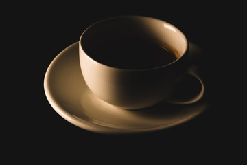 Empty white espresso cup on black background. Coffee cup rear view