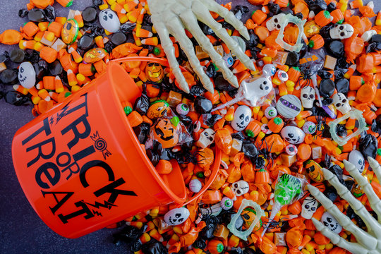 Halloween candy spilling out of orange trick or treat bucket
