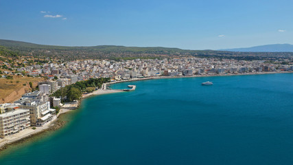 Aerial drone photo of famous seaside area and main town of Loutraki with sandy organised beach with turquoise clear sea and resorts, Greece