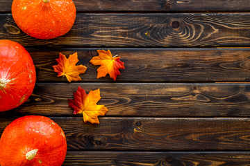 Autumn background with pumpkins and leaves on dark wooden table top view frame copy space