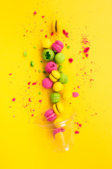 Colored, bright, sweet macaroons on a yellow background. Antigravity. Asymmetry.