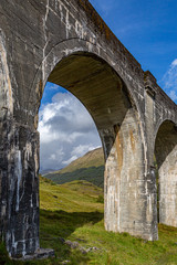 Naklejka premium The Glenfinnan Viaduct in the Scottish Highlands, with rugged green mountains behind