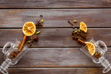 New Year beverage. Ingredients for mulled wine in glasses on dark wooden background top view copy...