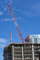 Close-up view of construction of highrise apartment building with crane on top