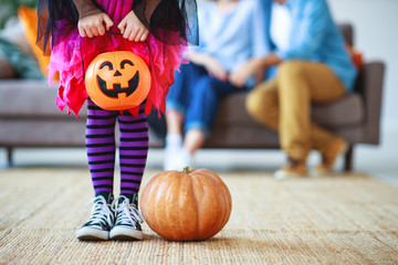 concept of Halloween. child girl legs in witch costume with pumpkin.