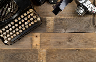 Vintage retro typewriter and analog film camera on wooden table background top view flat lay from...