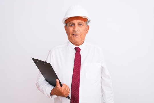 Senior architect man wearing security helmet holding clipboard over isolated white background with a happy face standing and smiling with a confident smile showing teeth