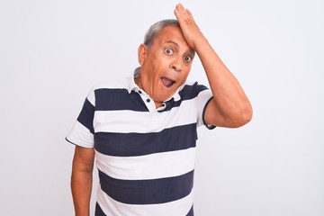 Senior grey-haired man wearing casual striped polo standing over isolated white background...