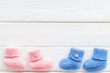 Booties for newborn boy and girl on white wooden background top view mockup