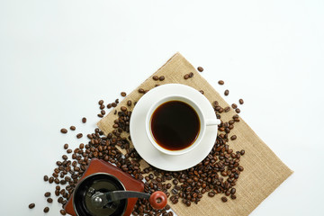 brown roasted coffee beans and coffee cup