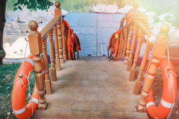 Entrance to the boat station with life jackets on the railing. The dock with paddle boats in summer...